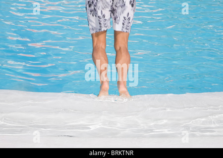 L'homme de plonger dans une piscine bleu en noir et blanc shorts Banque D'Images