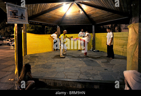 Les gens regardent un écran d'une Capoeira art martial brésilien créé dans les années 1500 par les esclaves africains dans le marché de Buzios Banque D'Images