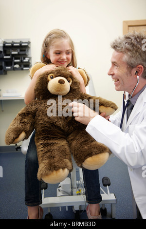 Médecin à écouter le cœur de l'ours en peluche Banque D'Images