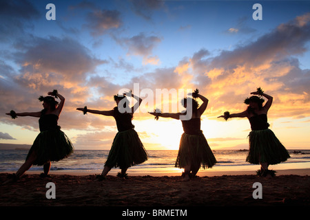 Silhouette de danseurs hula au coucher du soleil à Palauea Beach, Maui, Hawaii. Banque D'Images