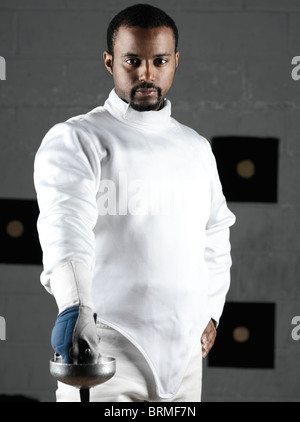 Portrait d'un tireur portant des uniformes d'escrime dans une salle de sport Banque D'Images