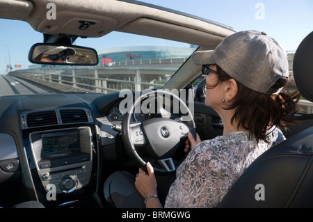 Les femmes matures, cheveux foncés, lunettes, profil, vue de côté, la conduite voiture décapotable, Londres, Westfield Shopping Centre, England, UK Banque D'Images