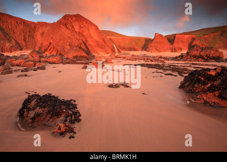 Lueur rouge du coucher de soleil sur les falaises de la baie Sandymouth, North Cornwall, England UK Banque D'Images