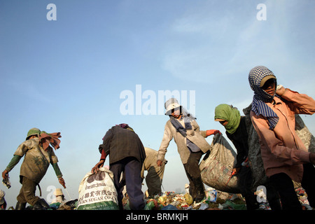 Les travailleurs sont la marche sur la corbeille lors de la recherche dans les ordures à la décharge de Stung Meanchey à Phnom Penh, Cambodge. Banque D'Images