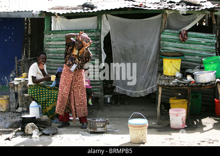 Deux femme avec deux jeunes enfants à l'extérieur de leur habitation de fortune Banque D'Images