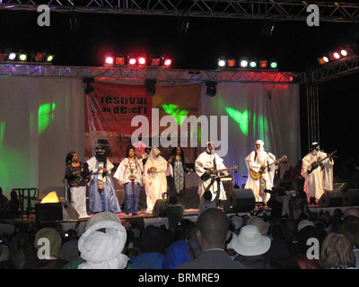 Un groupe d'hommes et femmes touareg sur scène au Festival dans le désert Banque D'Images