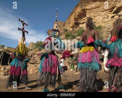 Les danseurs Dogon portant des masques et de longues jupes de paille colorée effectuant une danse de cérémonie Banque D'Images