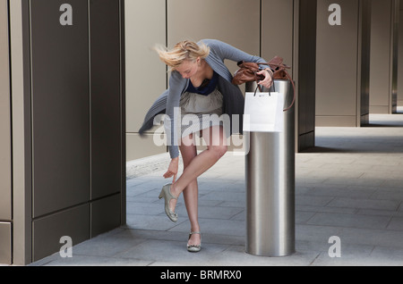 Woman with shopping chaussures de réglage Banque D'Images