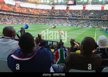 Vue arrière d'un soufflage des partisans de soccer pendant les vuvuzelas la coupe du monde 2010 Banque D'Images