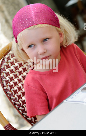 Stock photo d'une fillette de quatre ans en attente à une table de restaurant. Banque D'Images