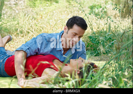 Couple romantique couché dans l'herbe haute Banque D'Images