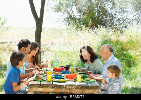 Family eating meal on outdoor table Banque D'Images