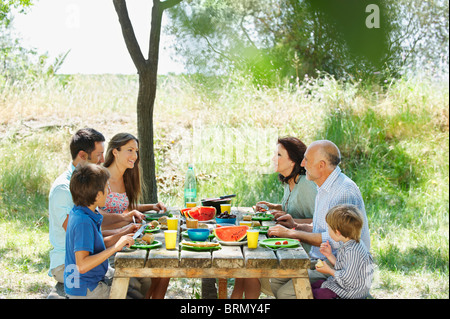 Family eating meal on outdoor table Banque D'Images