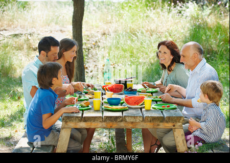 Family eating meal on outdoor table Banque D'Images