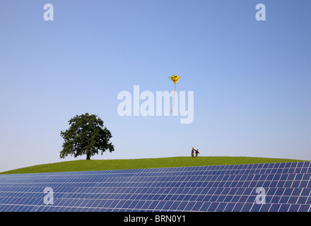 Les garçons flying kite à solar power station Banque D'Images