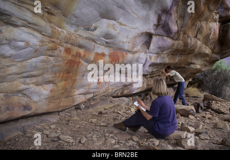 Un artiste et un photographe d'examiner de près les peintures Bushman dans le Cedarberg Banque D'Images