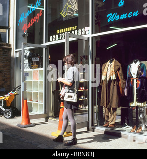 Une jeune femme à la mode debout à l'entrée du magasin 'Absolute Vintage' dans Hanley Street Shoreditch East London UK KATHY DEWITT Banque D'Images