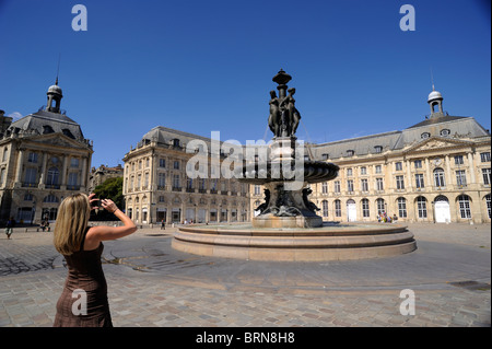 France, Bordeaux, place de la Bourse, touriste prenant une photo à la fontaine des trois Grâces Banque D'Images