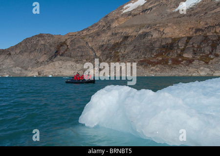 Le Groenland, côte sud-est, Skjoldungen Fjord. Les touristes explorant les Thryms zone Glacier en zodiac près de gros iceberg. Banque D'Images