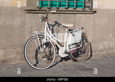Vélo blanc leaning against wall à Pise, Italie Banque D'Images