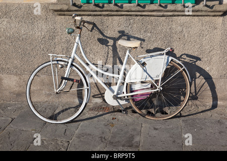Vélo blanc leaning against wall à Pise, Italie Banque D'Images
