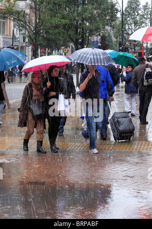 Les clients de la rue sur un jour froid et pluvieux. Banque D'Images