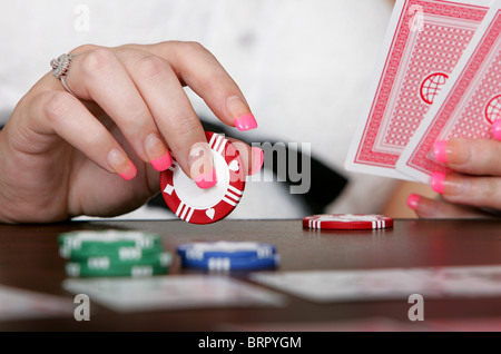 Close up of a woman holding cards jouer avec un jeton de poker Banque D'Images