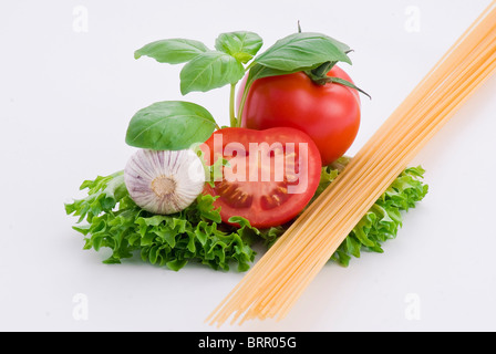 Les pâtes, les tomates, le basilic et l'ail sur fond blanc Banque D'Images