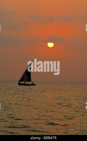 Les pêcheurs sur un dhow au coucher du soleil Banque D'Images