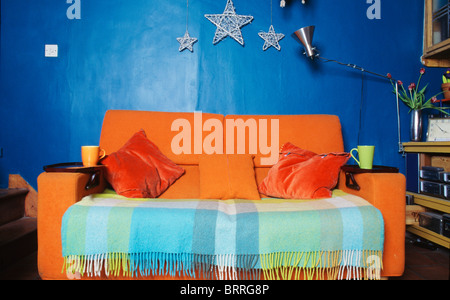 Turquoise et vert pâle vérifié jeter sur canapé orange vif en économie bleu vif-style living-room Banque D'Images