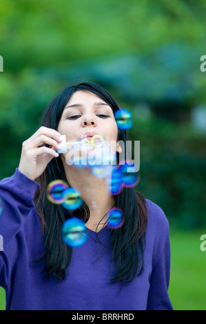Belle jeune femme faisant des bulles dans le green with copy space Banque D'Images