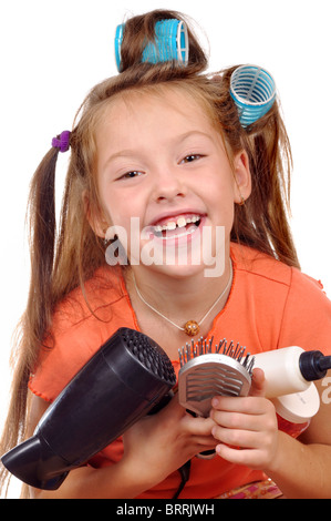 Fille avec un peigne dans les bigoudis sur fond blanc Banque D'Images