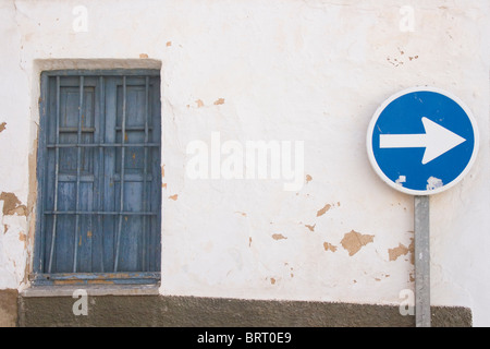 Gardez la droite Bleu signe contre mur blanchis peeling et vieille fenêtre bleu Banque D'Images