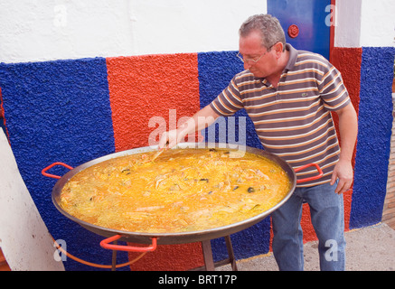 La cuisine de l'homme grande paella à la fête de l'amande, Almogia village, province de Malaga, Malaga, Espagne. Banque D'Images
