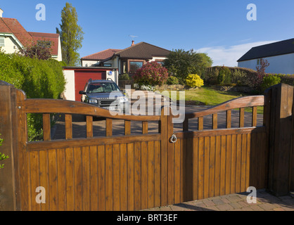 Bungalow jardin avant, portes et dur avec voiture garée, Wirral, Merseyside, Angleterre Banque D'Images