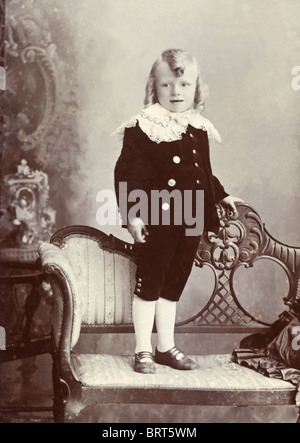 Portrait d'Edwardian garçon avec cheveux en boudins portant costume en velours avec col dentelle vers 1906 Banque D'Images