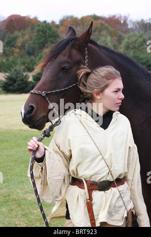 Un cheval arabe tenu par une jeune fille dans une tenue de la frontière de l'ouest Banque D'Images