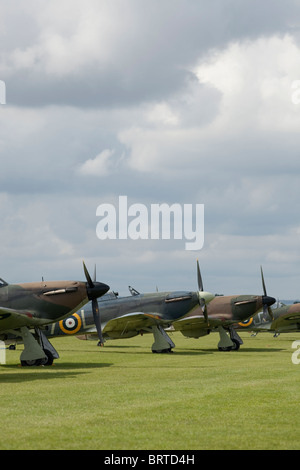 Restauré 3 Hurricane alignés sous un ciel de Cambridgeshire avec un Spitfire dans l'arrière-plan Banque D'Images