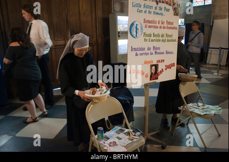 Paris, France - Nun catholique collecte de contributions, argent du public, à l'intérieur de la cathédrale notre-Dame, différentes cultures religion, Église catholique française, pratique religieuse européenne Banque D'Images