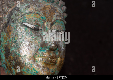 Un vieux Bouddha de bronze sur un fond noir à Ayuthaya Banque D'Images