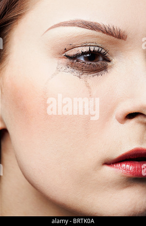 Close-up portrait of beautiful crying girl avec des traînées de mascara Banque D'Images