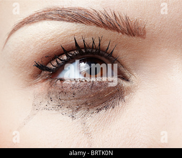 Close-up portrait of beautiful crying girl avec des traînées de mascara Banque D'Images