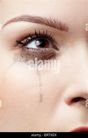 Close-up portrait of beautiful crying girl avec des traînées de mascara Banque D'Images