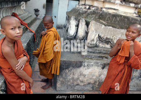 Les jeunes moines bouddhistes khmers sont mise sur leurs robes orange avant une cérémonie dans un temple de Phnom Penh, au Cambodge.. Banque D'Images