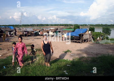 Une famille quitte un bidonville de squatteurs où les gens vivent dans la pauvreté sur la rive d'un fleuve du Mékong dans la région de Kampong Cham, au Cambodge. Banque D'Images