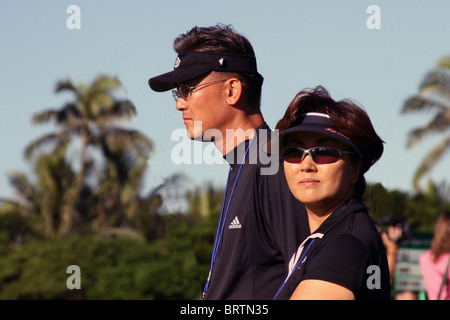 15 ans, Michelle Wie's parents la suivre sur le cours pendant une ronde de pratique avant l'ACGP Sony Open 2005 à Hawaii. Banque D'Images