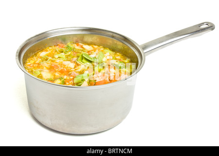 Bouillon de légumes rustiques et le jambon dans une casserole en acier inoxydable isolé sur blanc. Banque D'Images