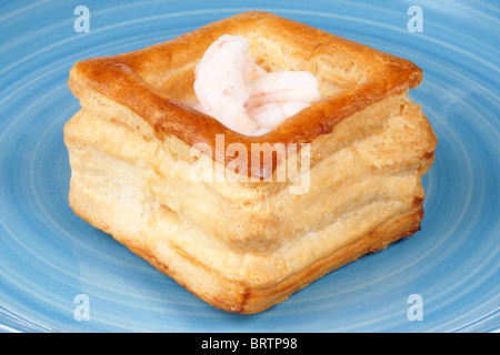 Close-up of a squared vol-au-vent farci de petites crevettes cuites sur une plaque bleue Banque D'Images