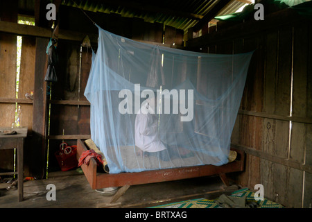 Cambodge Phala Lekha (15) organisation de la moustiquaire au-dessus de son lit, Kamphun village, district de Stung Treng. PHOTO par SEAN SPRAGUE Banque D'Images