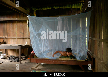 Cambodge Phala Lekha (15) organisation de la moustiquaire au-dessus de son lit, Kamphun village, district de Stung Treng. PHOTO par SEAN SPRAGUE Banque D'Images